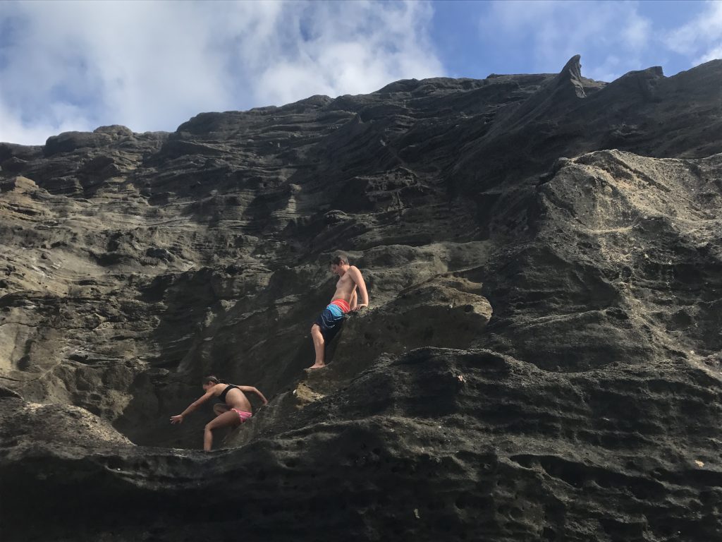 hawaii eternity beach kids climbing on rocks